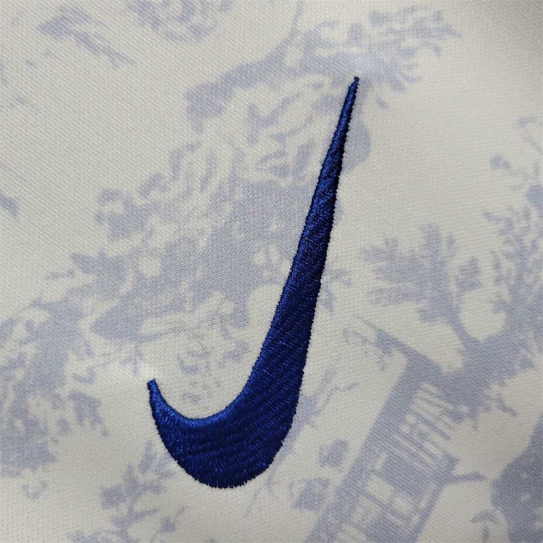 Leazofoot France 2022 away jersey featuring a white fabric with a blue toile de jouy pattern and embroidered blue swoosh