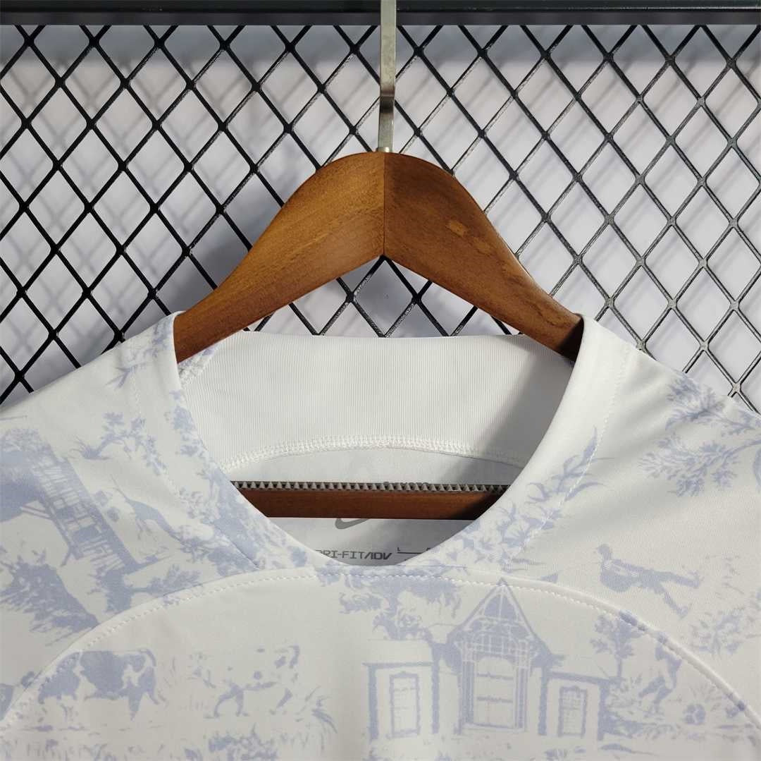 Leazofoot France 2022 away soccer jersey in white with blue toile de jouy pattern on a wooden hanger