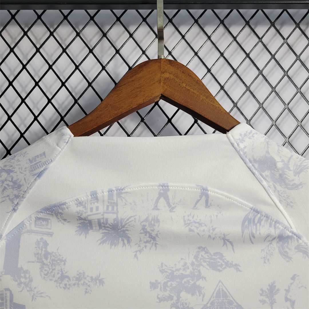 Leazofoot France 2022 away jersey featuring a white fabric with a subtle blue toile de jouy pattern on a hanger