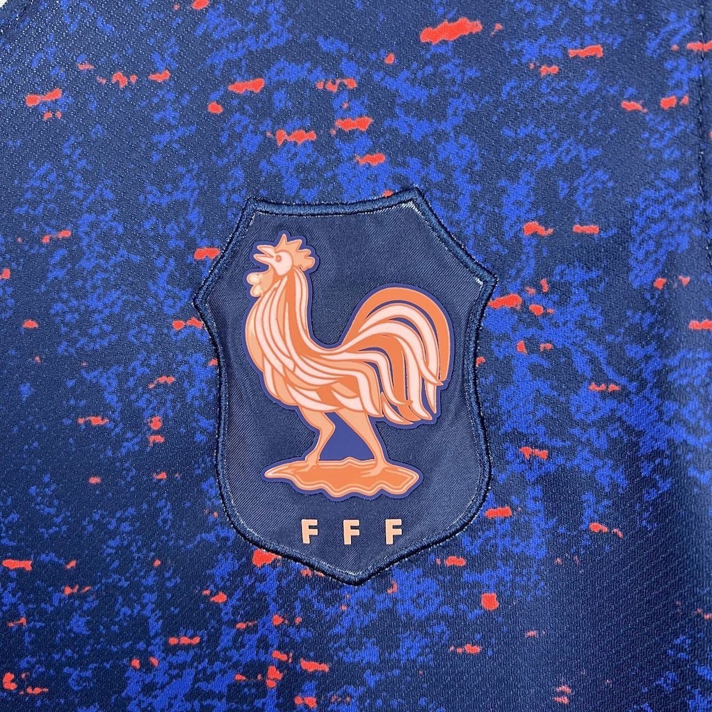 Leazofoot France 2025 home jersey featuring a blue fabric with red speckles and the FFF rooster crest emblem.