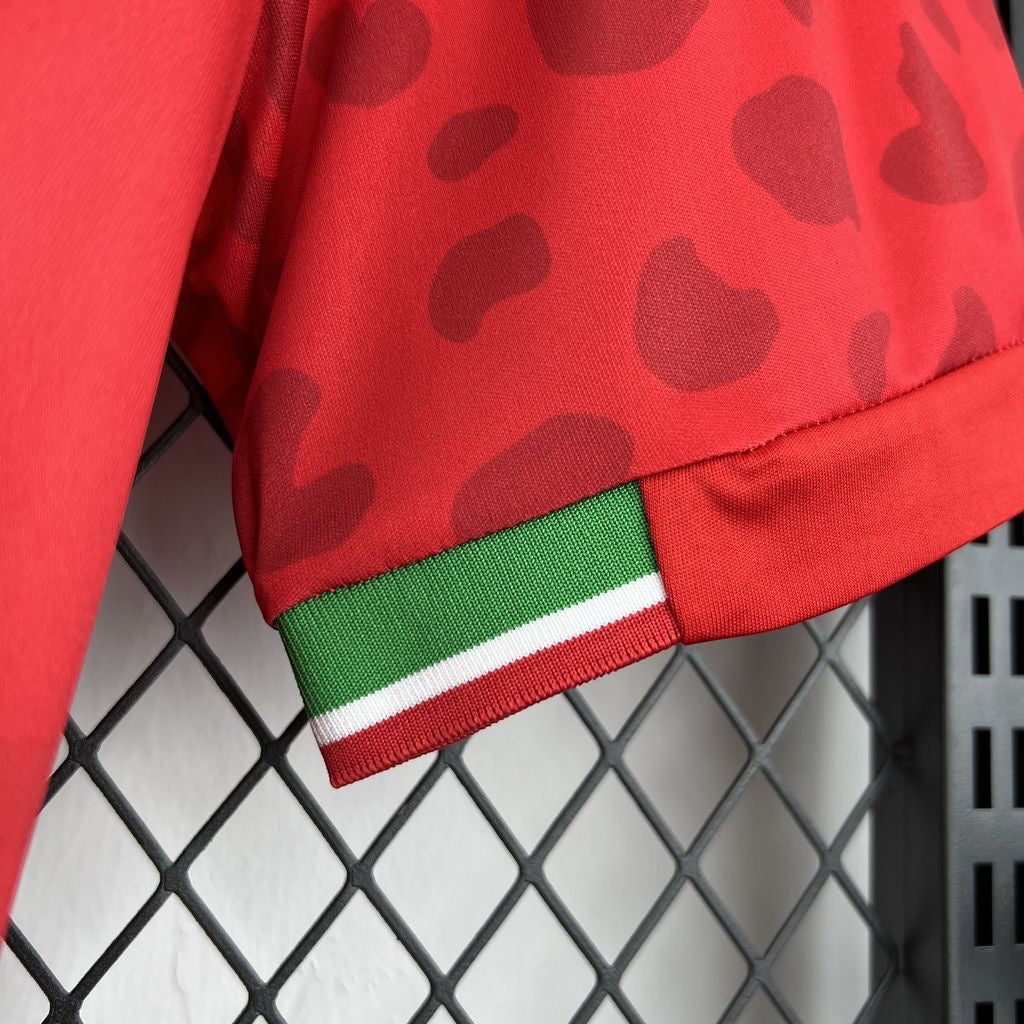 Leazofoot Iran 2026 away jersey sleeve detail featuring red fabric with dark red pattern and green white trim.