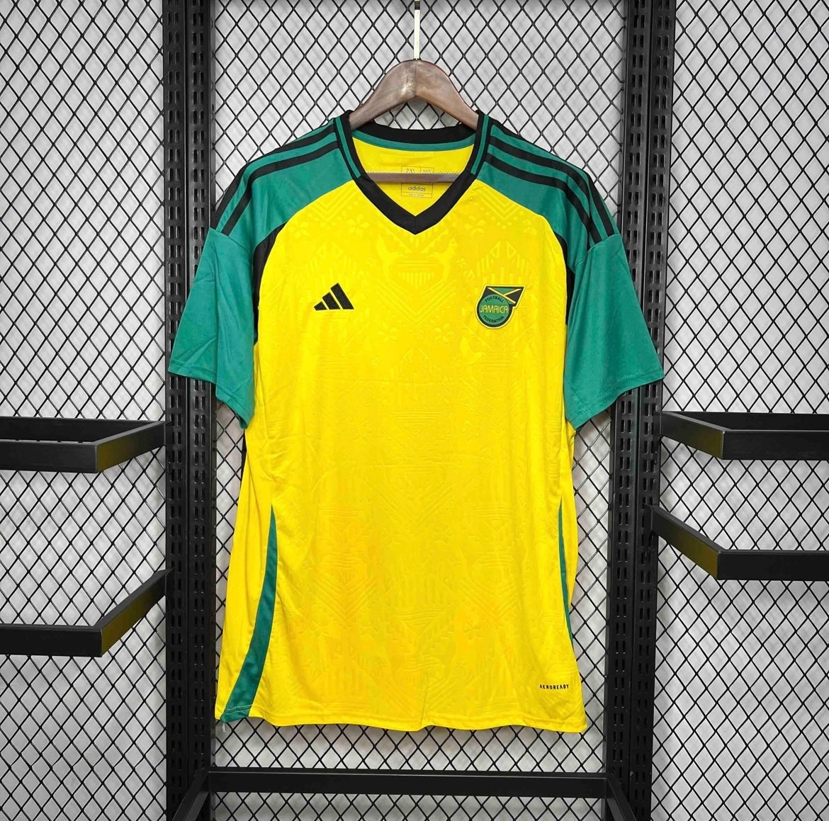 Leazofoot Jamaica 2024 home football jersey in yellow and green with V-neck and patterned fabric design.
