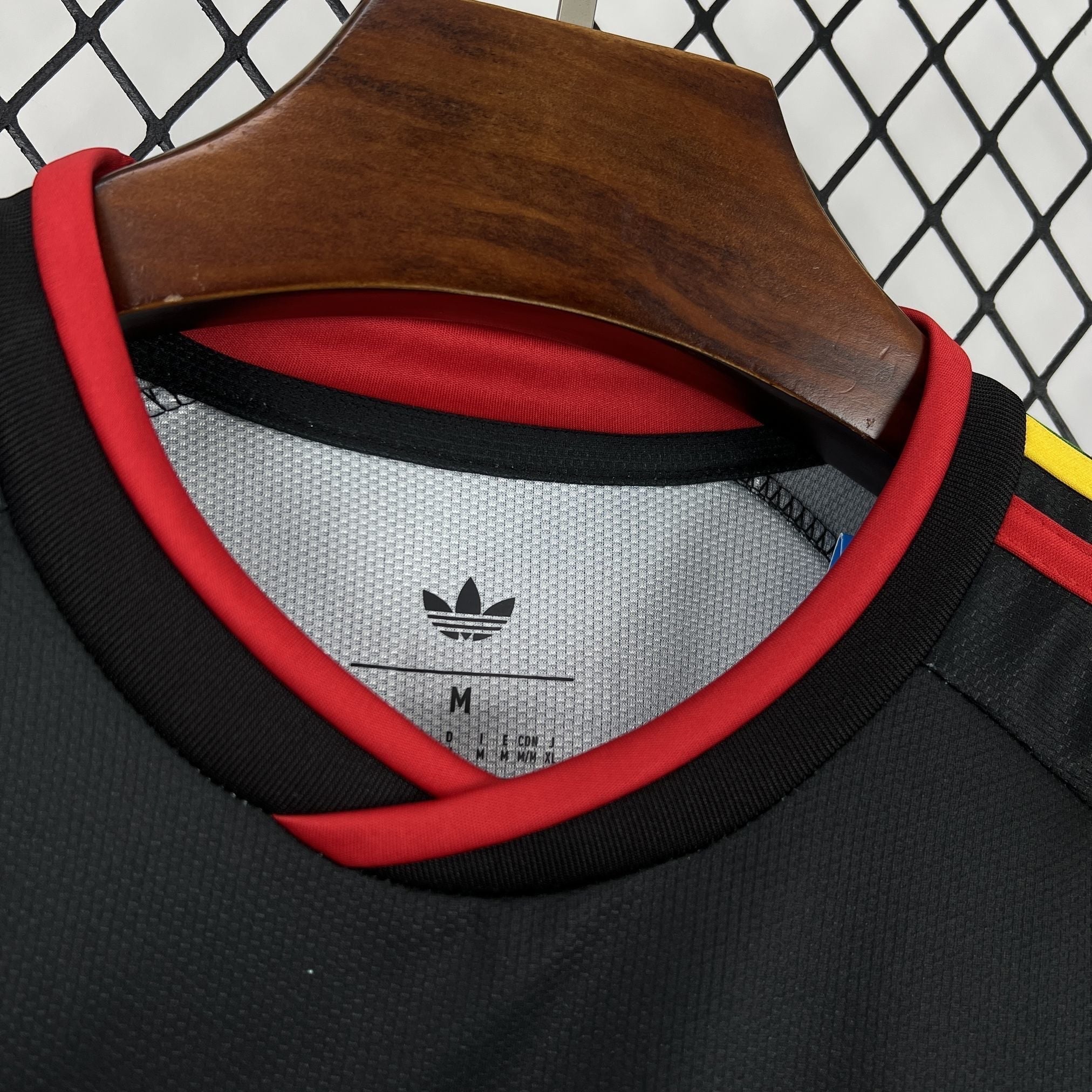 Leazofoot Jamaica 2026 away jersey featuring a black textured fabric with red collar trim and Adidas trefoil logo.