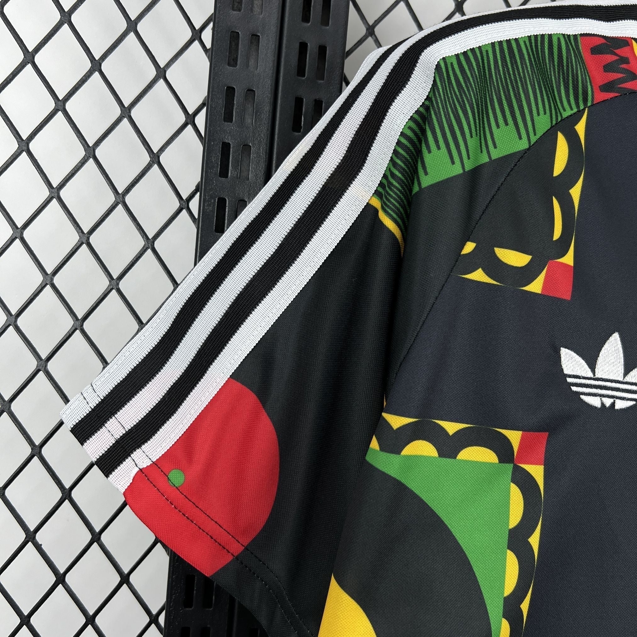 Leazofoot Jamaica 2026 concept soccer jersey in black with green, yellow, and red geometric patterns and stripes.