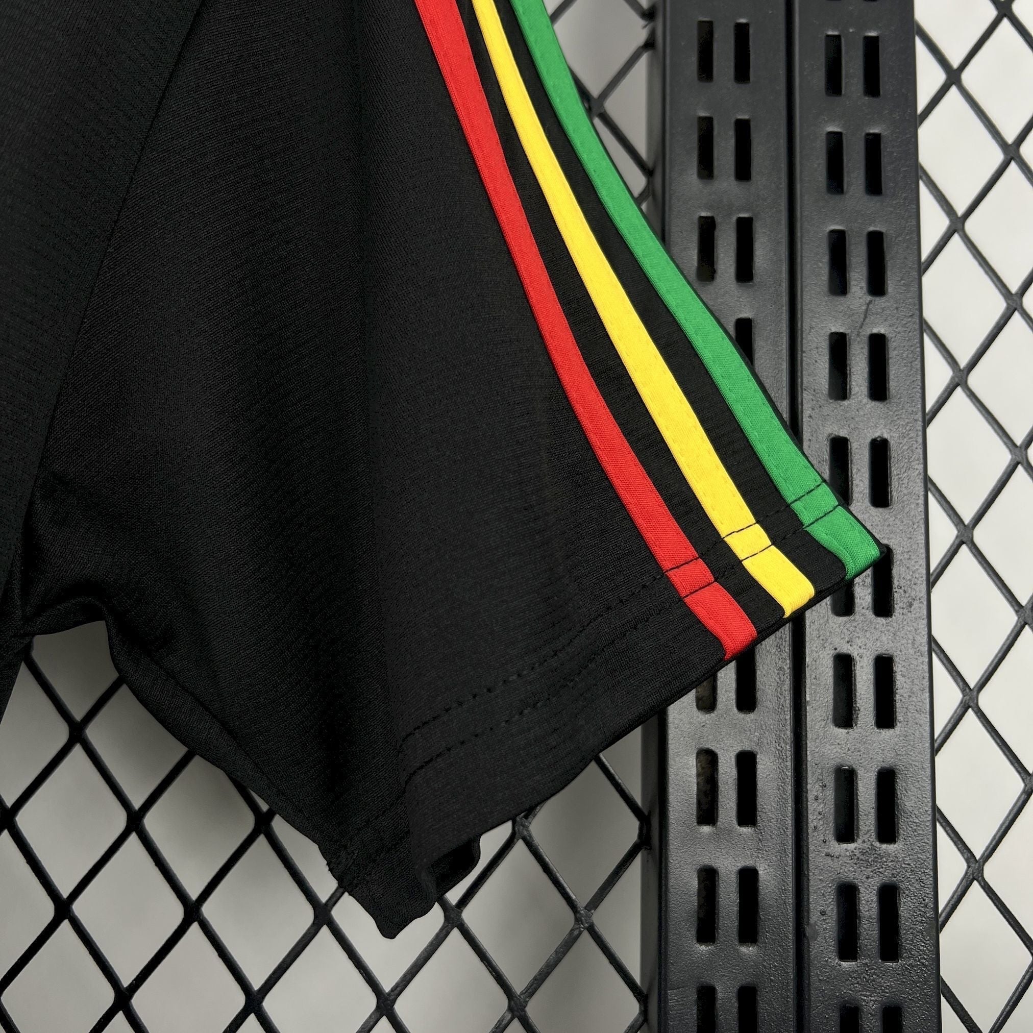Leazofoot Jamaica 2026 concept soccer jersey sleeve in black with red, yellow, and green striped trim.