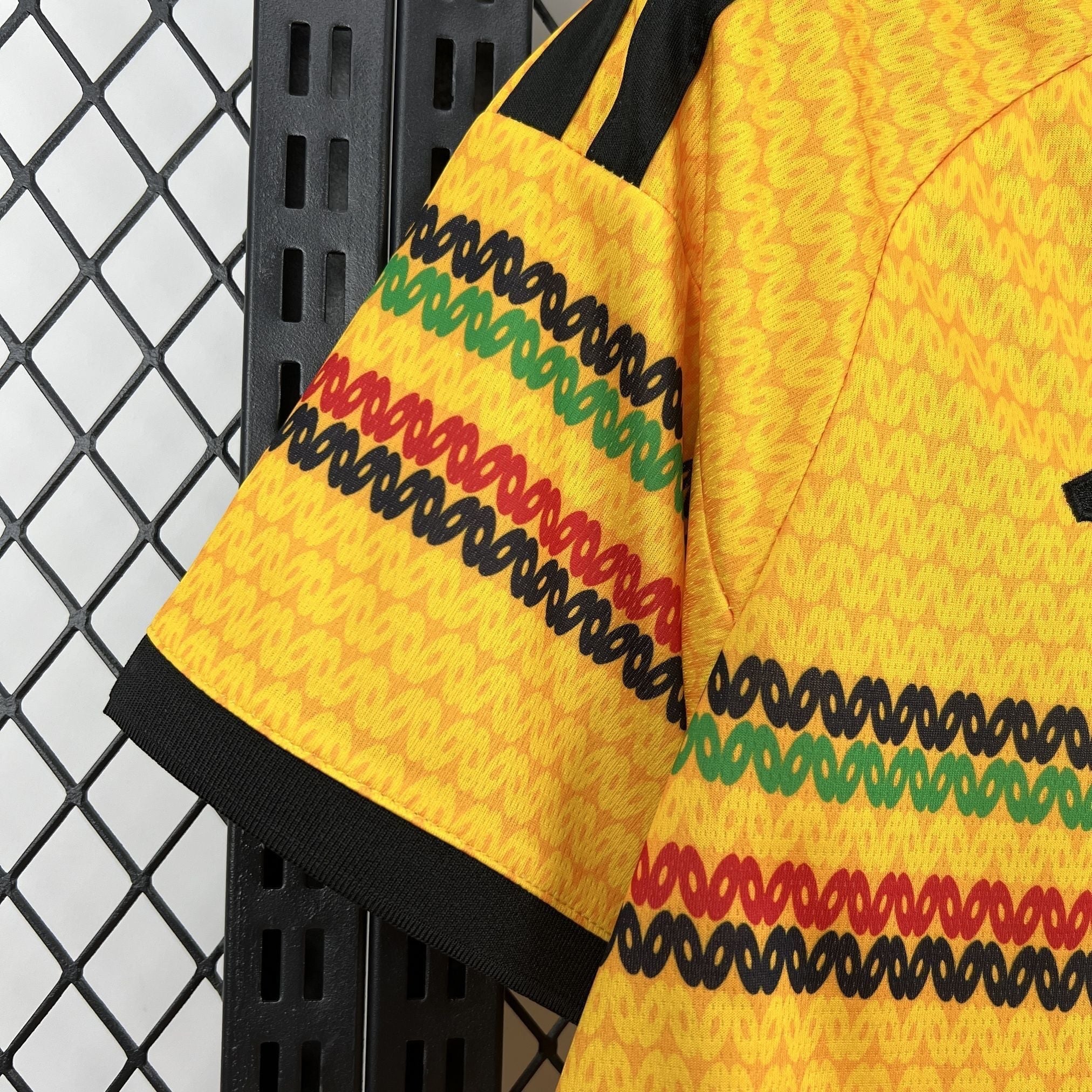 Leazofoot Jamaica 2026 home soccer jersey in yellow with black, green, and red patterned sleeve trim.