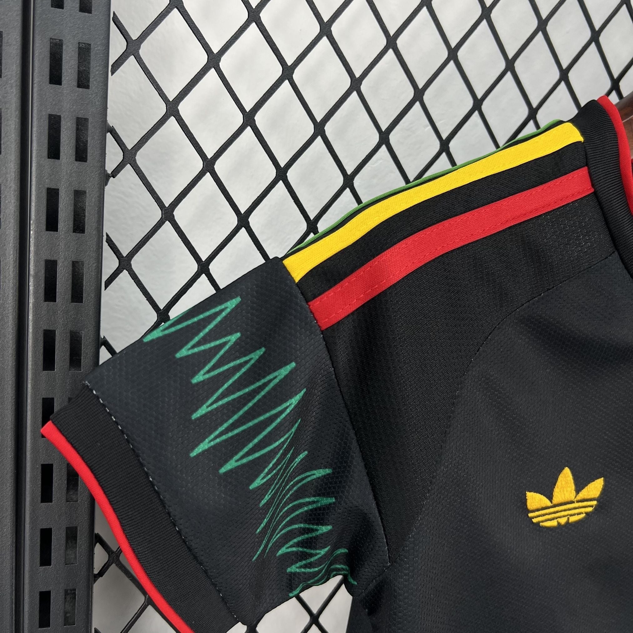 Leazofoot Jamaica 2026 kids away soccer jersey in black with yellow, green, and red trim and embroidered logo.