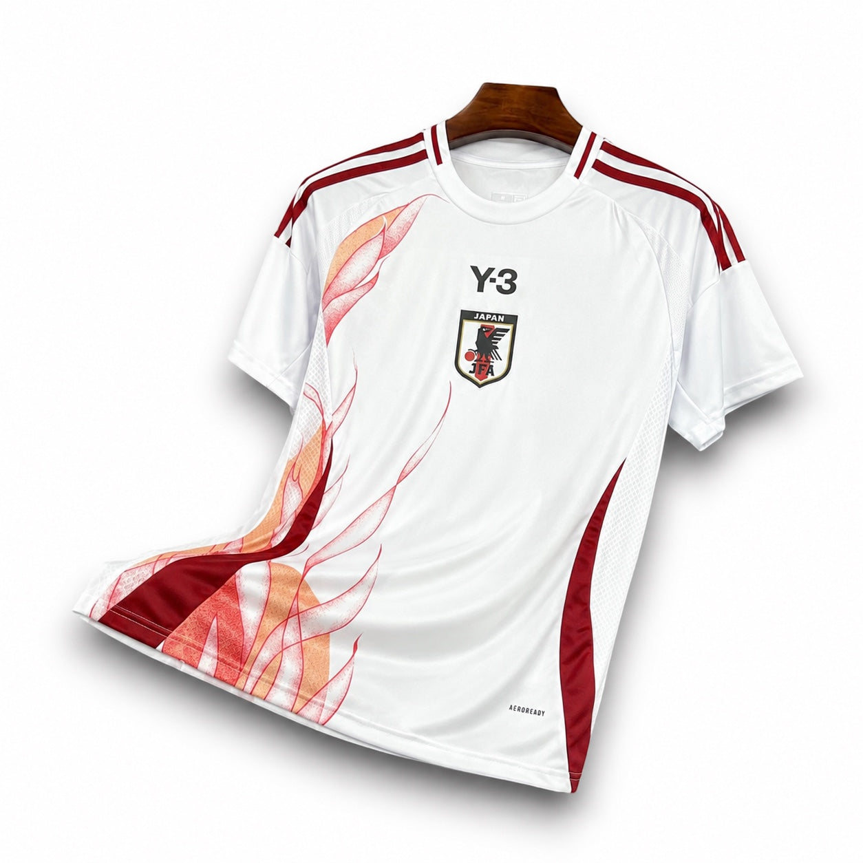 Leazofoot Japan 2024 away jersey in white with red flame graphic, Y-3 logo, and JFA crest on a wooden hanger.