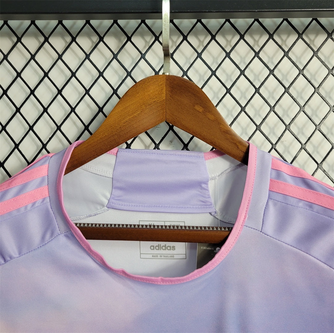 Leazofoot Japan 25/26 special edition soccer jersey in light purple with pink adidas stripes on a wooden hanger
