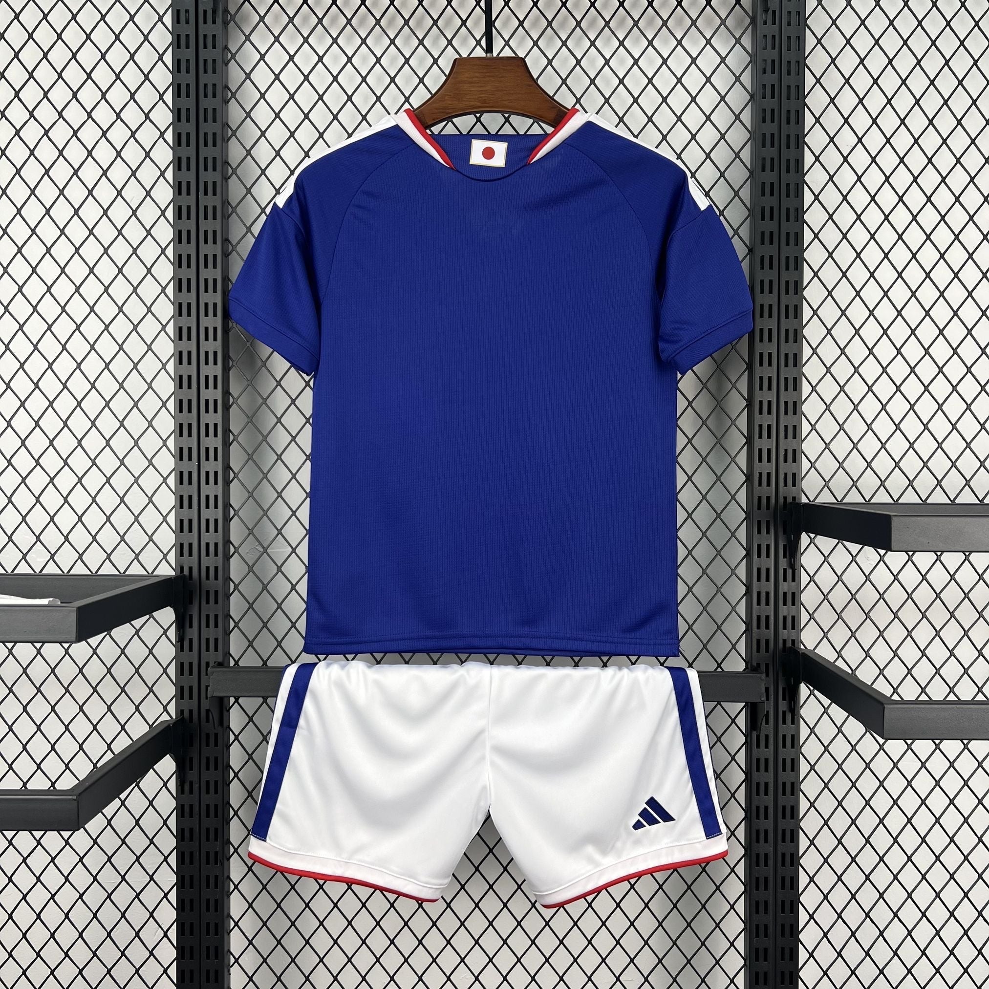 Leazofoot Japan kids' soccer uniform, royal blue jersey with white trim and Japanese flag detail, white shorts with blue stripes and red trim.