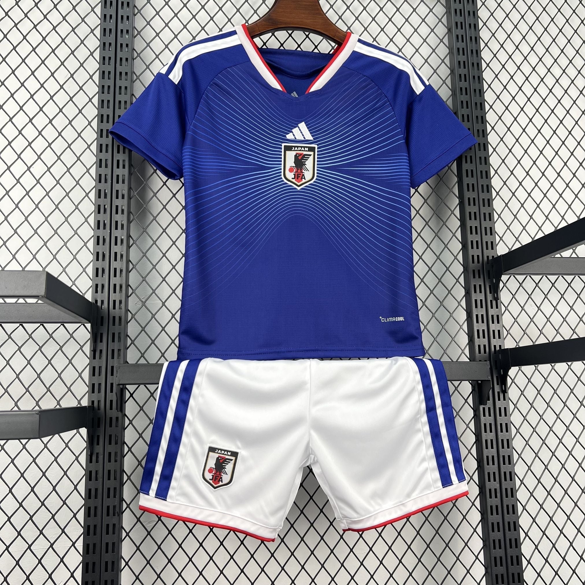 Leazofoot Japan kids' soccer uniform, blue jersey with white trim and graphic pattern, white shorts with blue stripes.