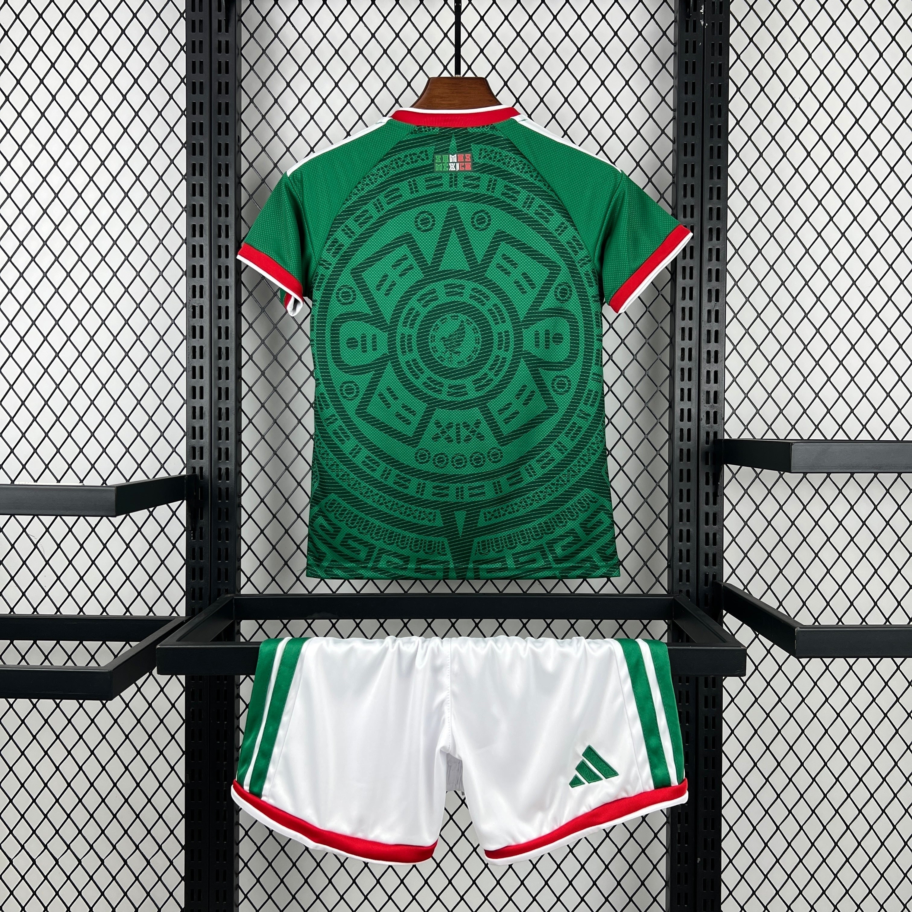 Leazofoot green children's soccer jersey with Aztec calendar design and white shorts with green and red trim.