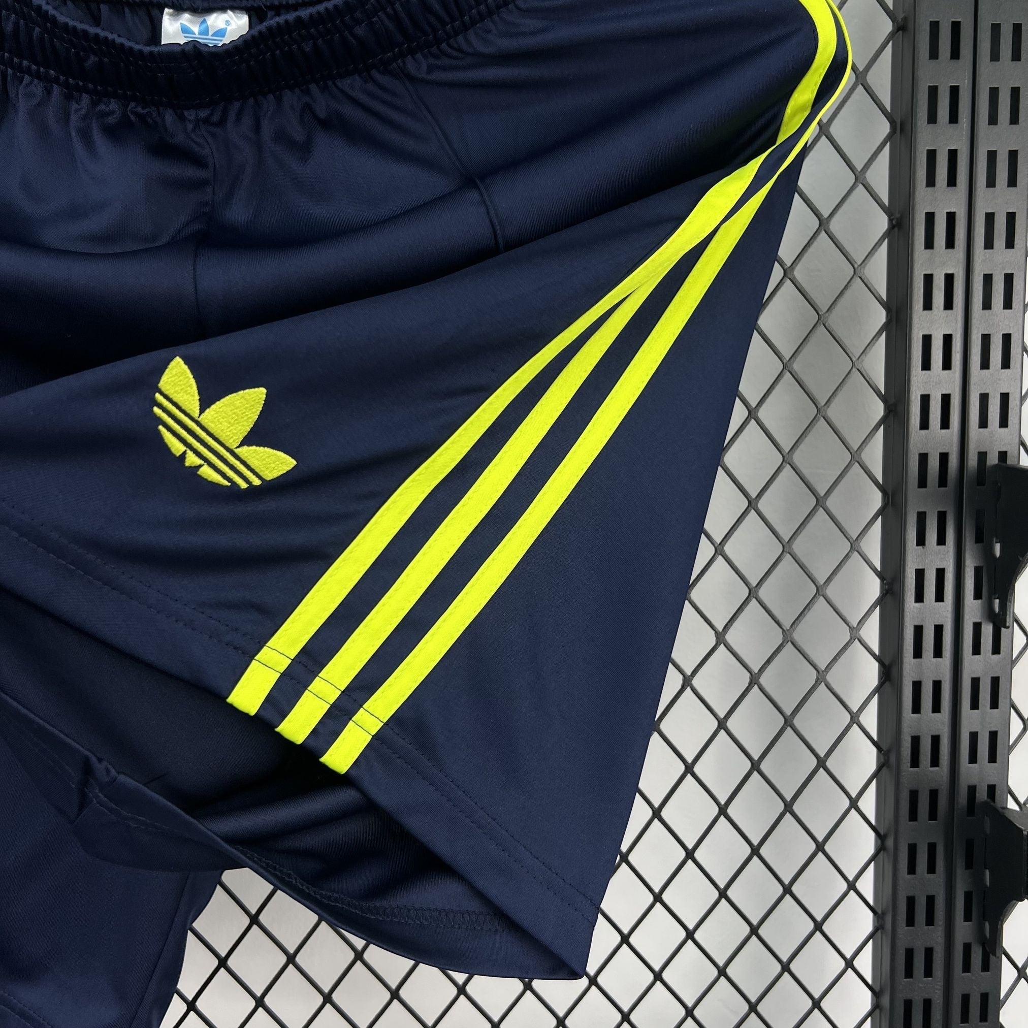 Leazofoot navy blue athletic shorts with yellow Adidas trefoil logo and three stripes.