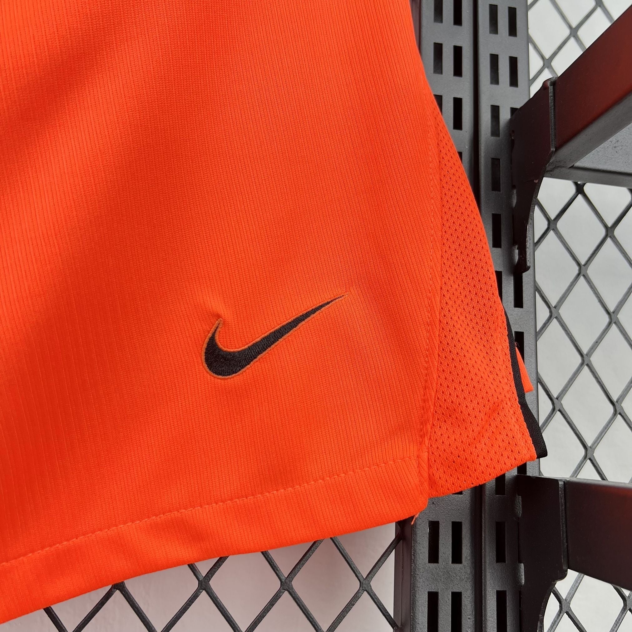 Leazofoot orange athletic shorts with black Nike swoosh logo and mesh side panels.