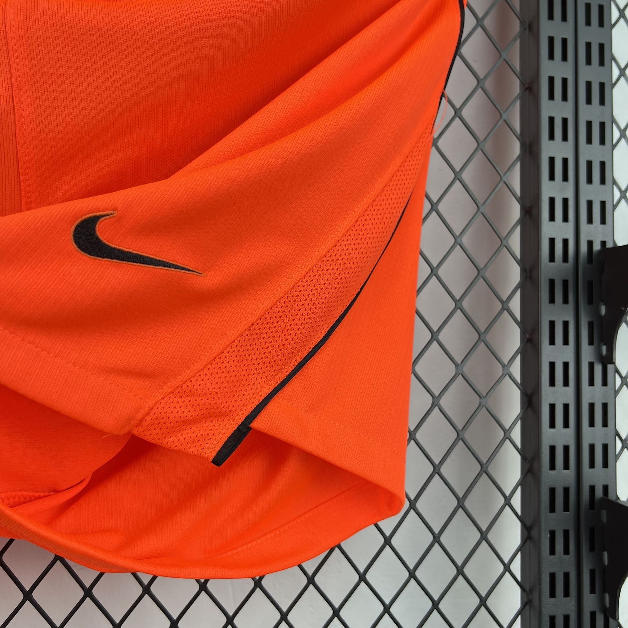 Leazofoot orange athletic shorts with black Nike logo and mesh panel details.