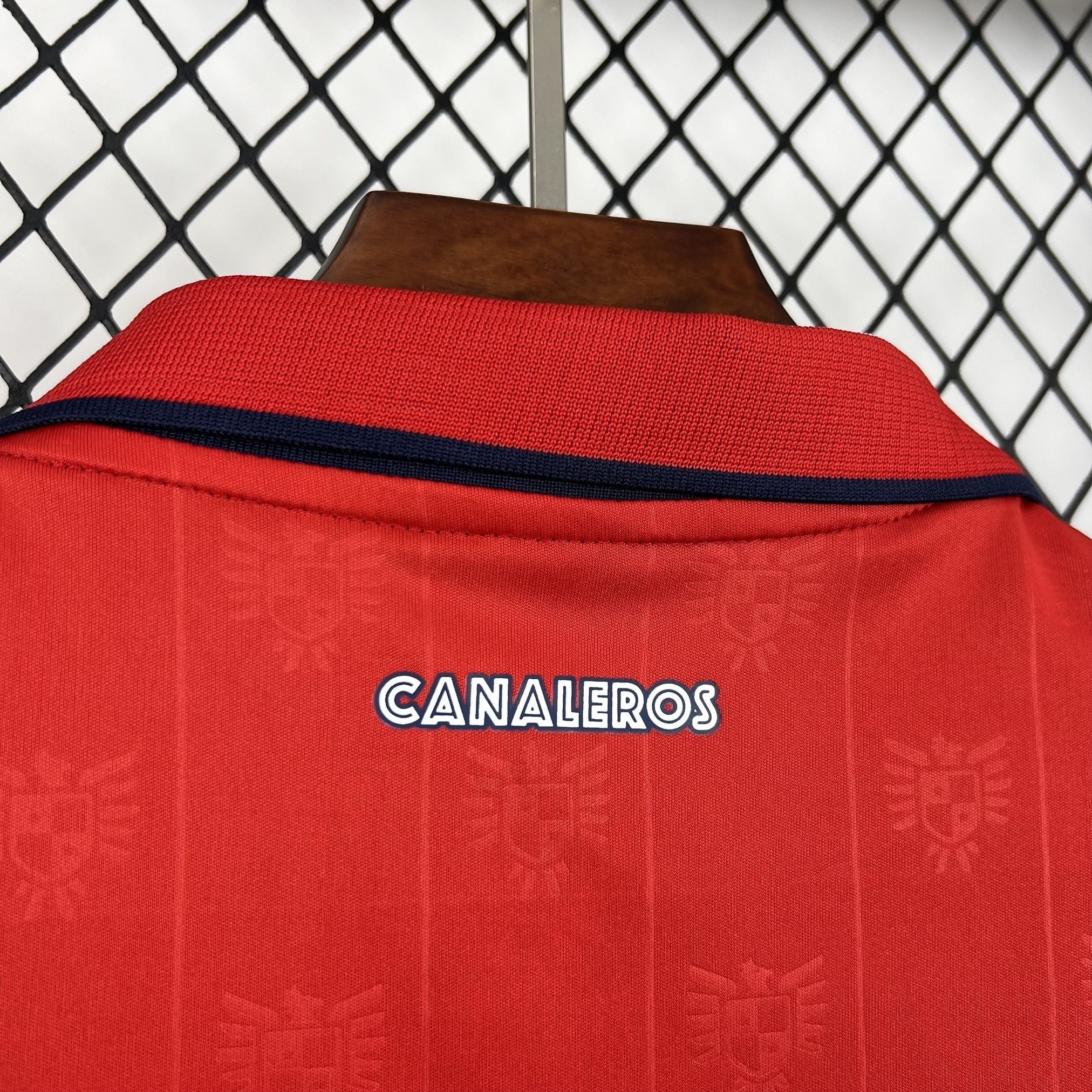 Leazofoot PANAMA 2026 home jersey, red with navy collar trim and embossed shield pattern.