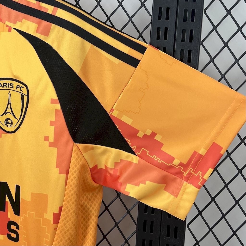 Leazofoot Paris FC 25/26 third jersey in yellow and orange with a pixelated pattern and black side panel detailing.