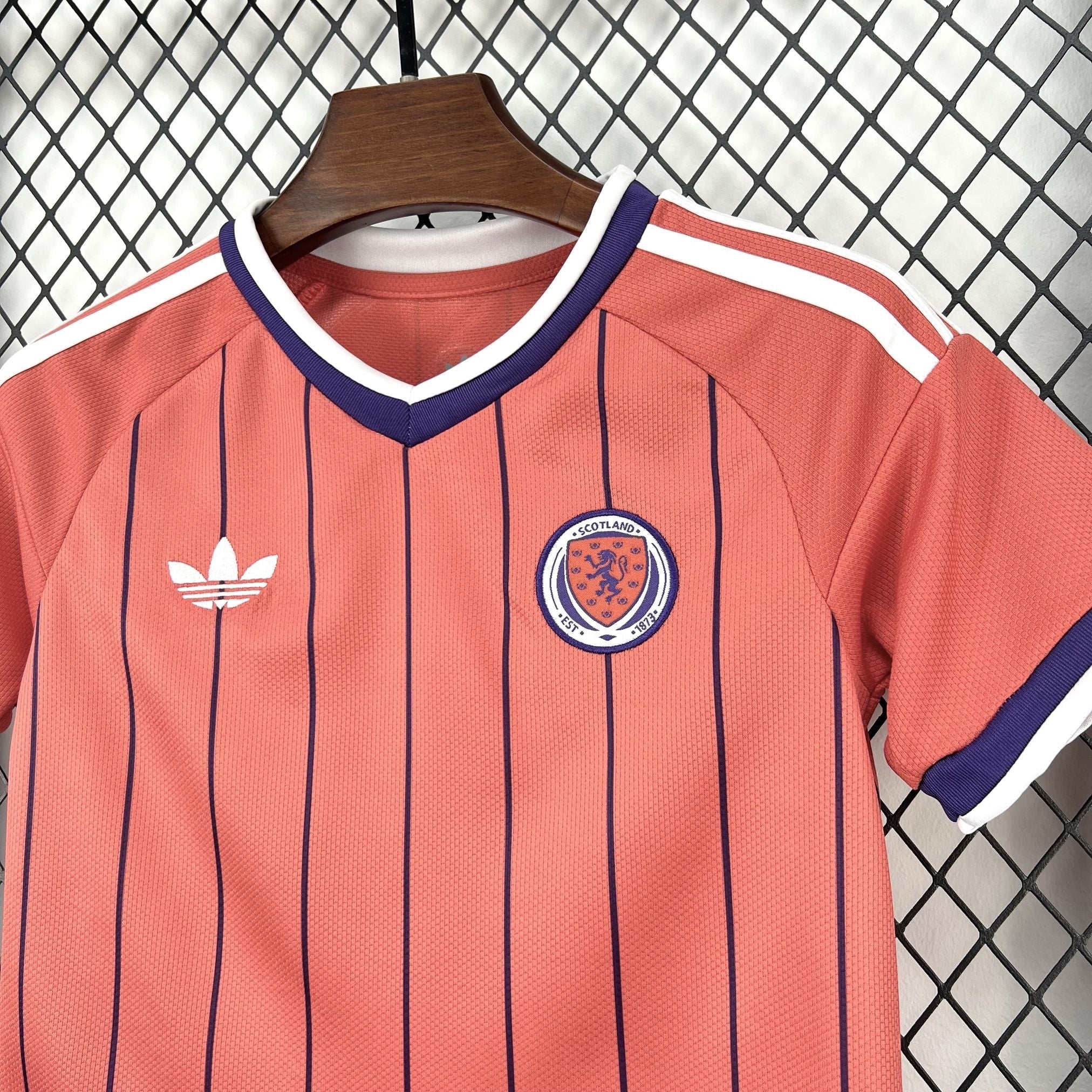 Leazofoot coral pink Scotland soccer jersey with navy pinstripes, white Adidas logo, and Scotland crest.