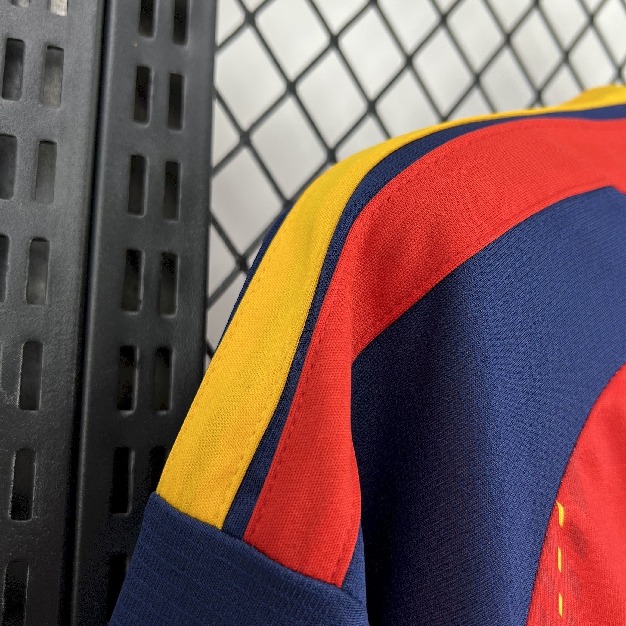 Leazofoot Spain 2026 home jersey with navy blue, red, and yellow stripes on the sleeves.
