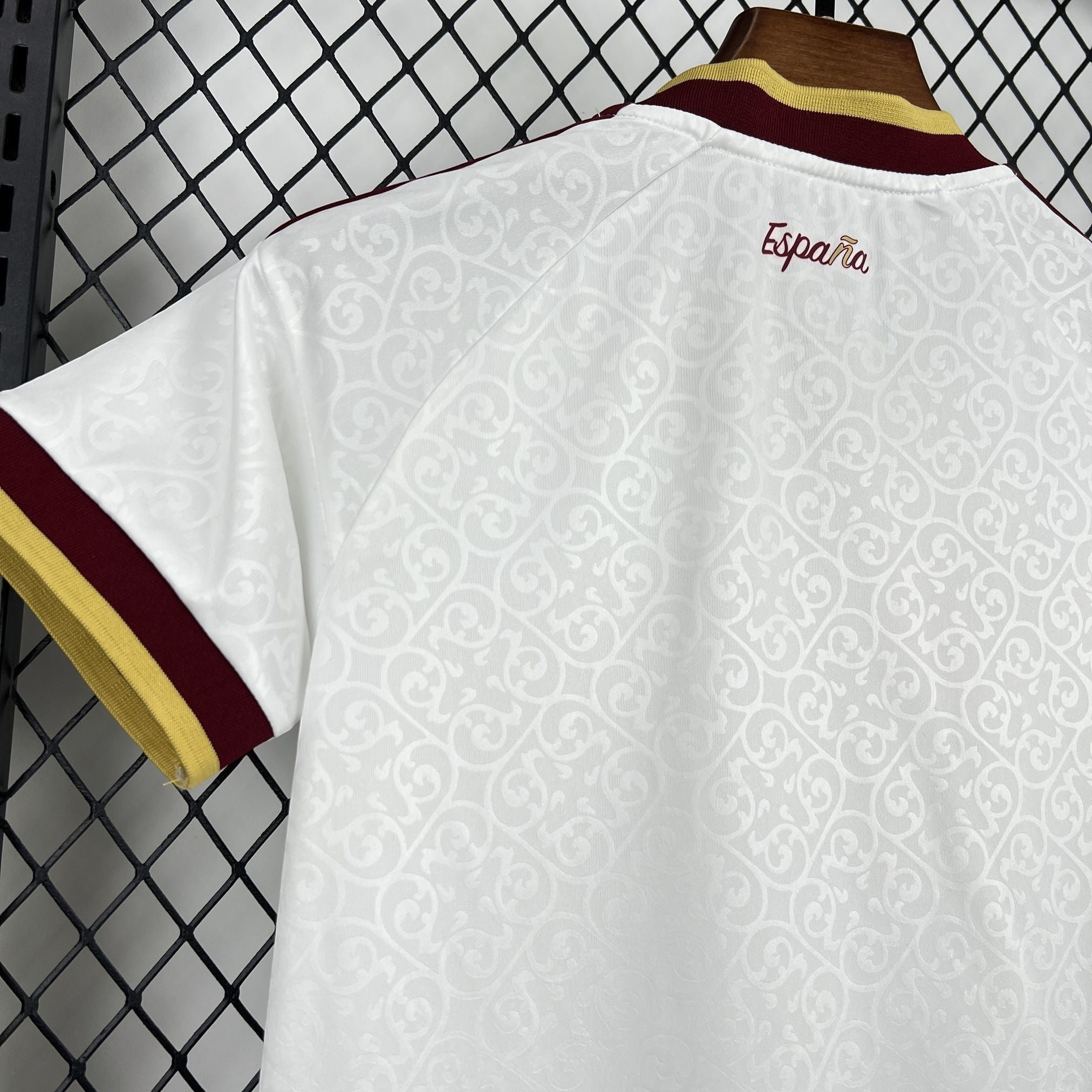 Leazofoot white Spain kids' football kit with maroon and gold trim on sleeves and collar. Features embossed pattern.