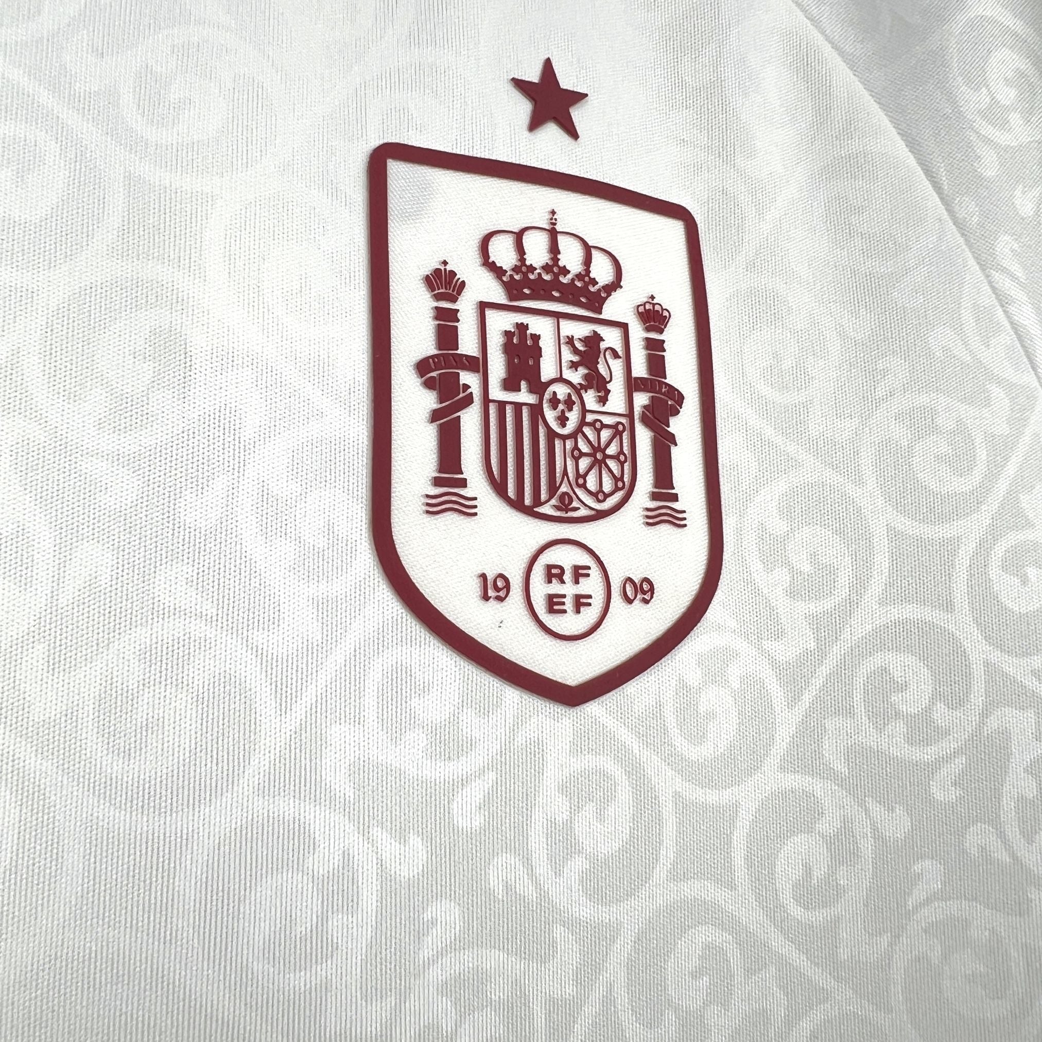 Leazofoot Spain kids' football kit 2026, white with red crest and star detail.