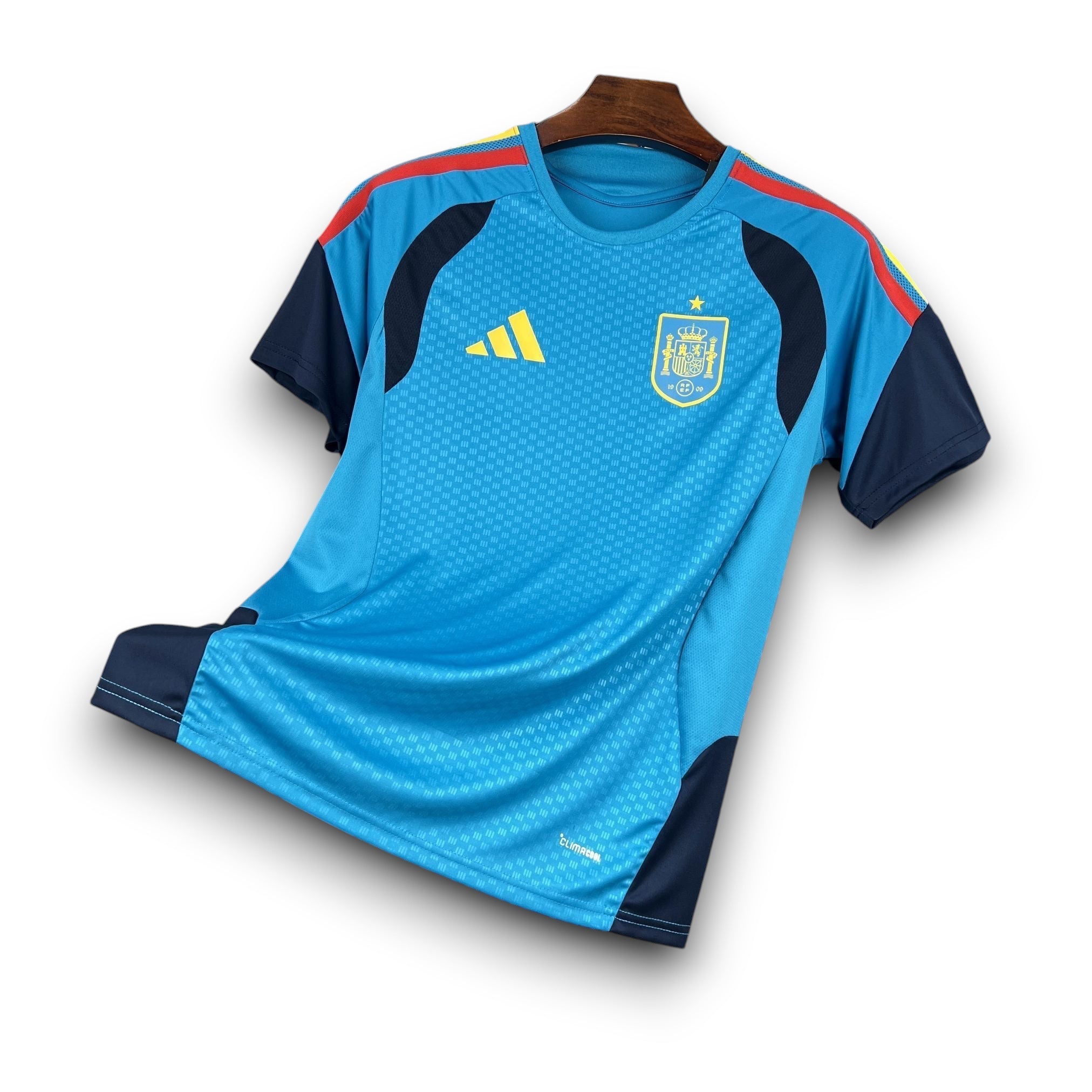 Leazofoot Spain pre-match football jersey, light blue with navy sleeves and accents, featuring the Spain crest and Adidas logo.