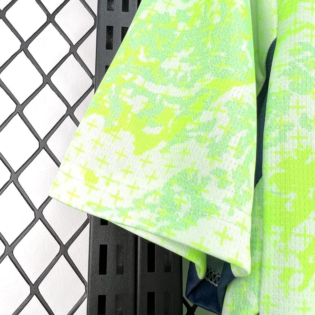 Leazofoot Switzerland 2026 away jersey sleeve in neon green with a subtle cross pattern and dark blue trim.